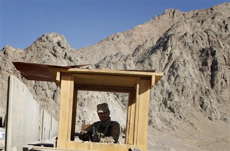 In this photo taken on Dec. 12, 2010 an Afghan police man controls the area from a security booth at a check point in Kandahar south of Kabul, Afghanistan. One year after President Barack Obama ordered a troop buildup to halt the Taliban's momentum, the war in Afghanistan has not broken decisively in favor of U.S.-led forces _ at least not yet. NATO forces have routed insurgents from their strongholds in southern Afghanistan, the Taliban's strongest region. But the militants have opened new fronts in the north and west and have stepped up attacks in the east. (AP Photo/Allauddin Khan)